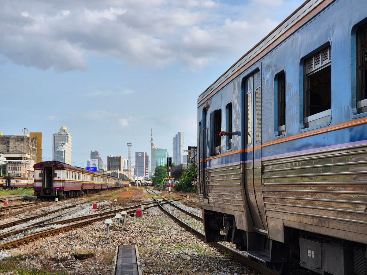 Thai trains and railway tracks leading toward the Bangkok skyline