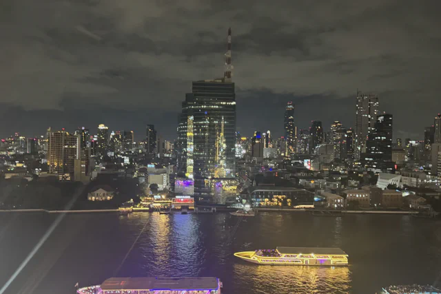 Illuminated boat traveling along the Chao Phraya River at night