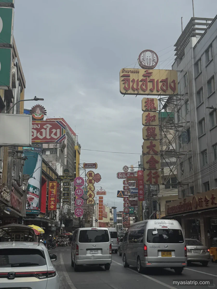 Traffic and illuminated shop signs on Yaowarat Road in Bangkok Chinatown