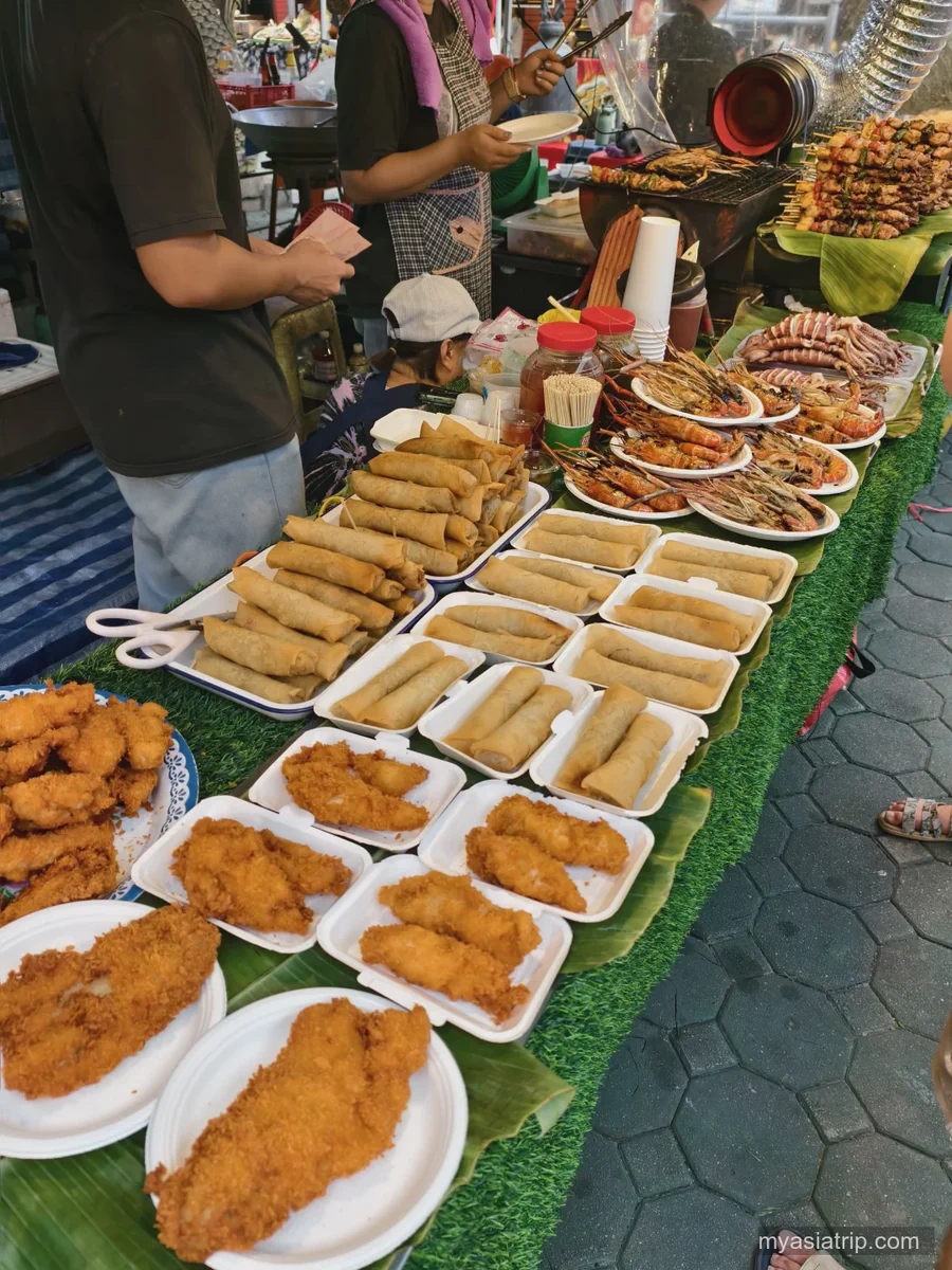 Cooked dishes displayed at a Chiang Mai street-food market