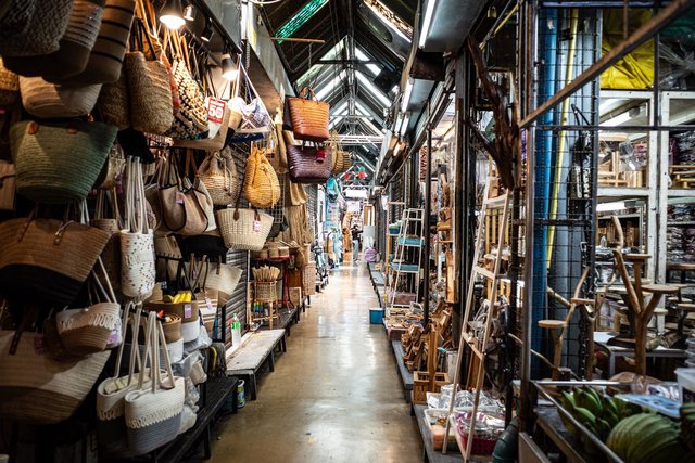 Shoppers walking between stalls at Chatuchak Weekend Market in Bangkok