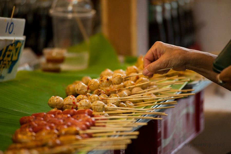 Thai street-food skewers being cooked over a grill