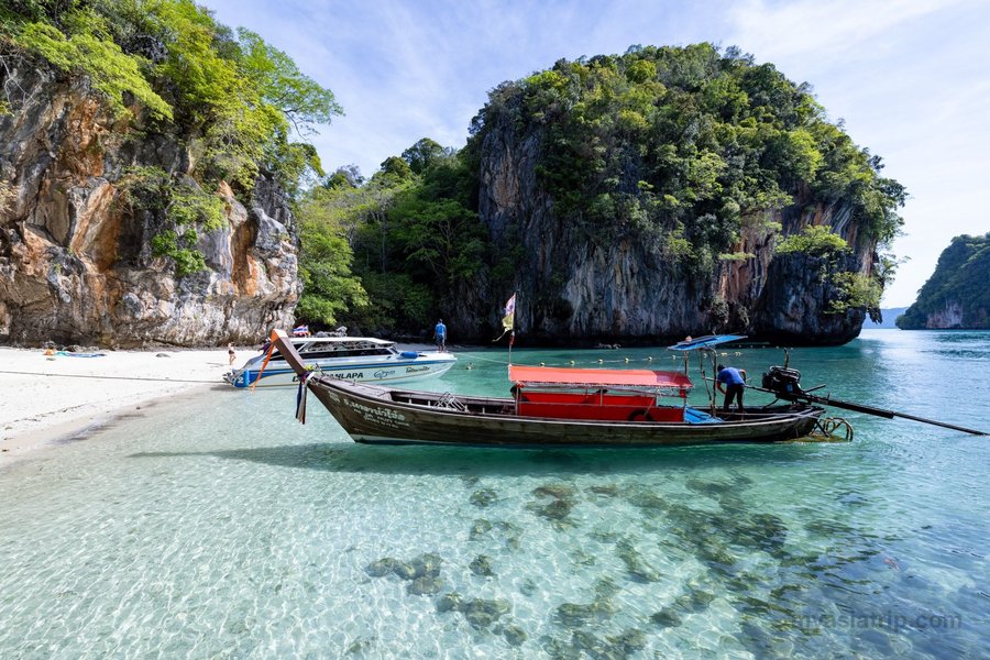 Long-tail boat resting in a quiet Thai island cove